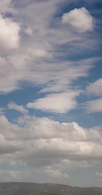 Timelapse of cloudy sky vertical footage with mountains.