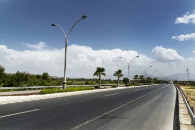 Straight road background with cloudy sky.