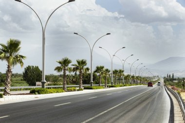 Straight road background with cloudy sky.