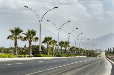 Straight road background with cloudy sky.