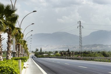 Straight road background with cloudy sky.