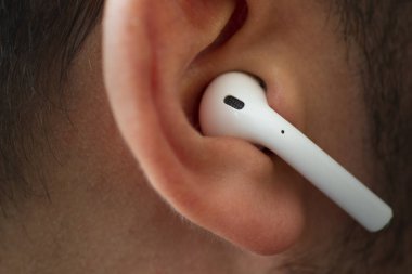 Izmir, Turkey - July  12, 2019: Close up shot of the one of Apple brand airpods on a caucasian white males ear.