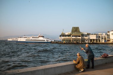 İzmir, Türkiye - 21 Ekim 2019: Feribot ve balıkçılar İzmir 'de Türkiye Konak' ta vapurla geziyorlar.