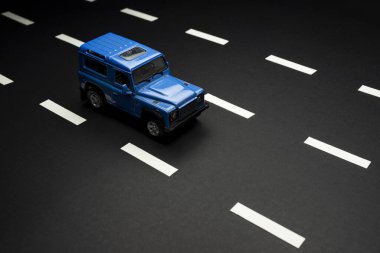 İzmir, Türkiye - 28 Temmuz 2019. Mavi bir SUv 'un üst ön görüntüsü. Siyah arka planda ve yol şeritlerinde eski moda bir tarz..