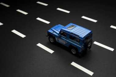 İzmir, Türkiye - 28 Temmuz 2019. Mavi bir SUv 'un üst arka görüntüsü. Siyah arka planda ve yol şeritlerinde eski moda bir tarz..