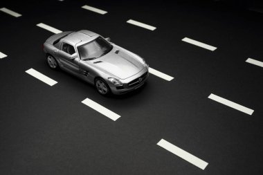İzmir, Türkiye - 28 Temmuz 2019: Gri Mercedes 300 SL Gullwing Oyuncak arabasının siyah arka plan ve karayolları üzerindeki üst ve ön görüntüsü.
