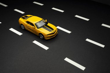 İzmir, Türkiye - 28 Temmuz 2019: Yol şeritli asfalt bir yolda iki kapılı ve siyah çizgili Chevrolet Camaro Sarı renkli bir spor arabanın üst ve ön görüntüsü.