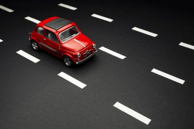 İzmir, Türkiye - 28 Temmuz 2019: Yol şeritli asfalt bir yolda kırmızı Fiat 500 model bir oyuncak otomobilin üst ve ön görüntüsü.