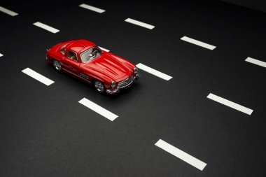 İzmir, Türkiye - 28 Temmuz 2019: Mercedes 300 SL Kırmızı renkli oyuncak araba asfalt yolda.