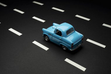 İzmir, Türkiye - 28 Temmuz 2019: Yol şeritli asfalt bir yolda mavi renkli 50 'li yılların oyuncak arabasının üst ve arka görüntüsü.