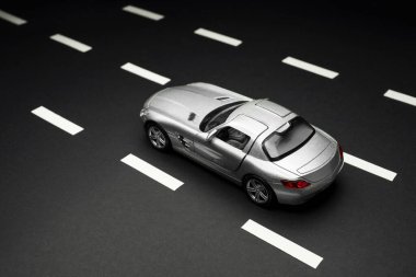 İzmir, Türkiye - 28 Temmuz 2019: Gri Mercedes 300 SL Gullwing Oyuncak arabasının siyah arka plan ve karayolları üzerindeki üst ve arka görüntüsü.
