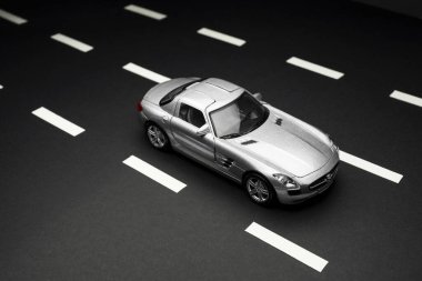 İzmir, Türkiye - 28 Temmuz 2019: Gri Mercedes 300 SL Gullwing Oyuncak arabasının siyah arka plan ve karayolları üzerindeki üst ve arka görüntüsü.