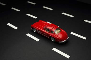 İzmir, Türkiye - 28 Temmuz 2019: Mercedes 300 SL Kırmızı renkli oyuncak araba asfalt yolda.