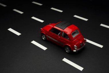 İzmir, Türkiye - 28 Temmuz 2019: Yol şeritli asfalt bir yolda kırmızı Fiat 500 model bir oyuncak arabanın üst ve arka görüntüsü.