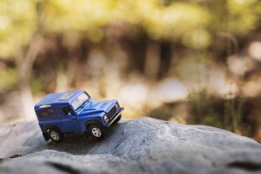 İzmir, Türkiye - 28 Temmuz 2019: Kayalıklarda eski moda bir model olan ve ön tarafta poz veren Mavi SUv