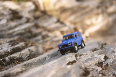 İzmir, Türkiye - 28 Temmuz 2019: Kayalıklarda eski moda bir model olan ve ön tarafta poz veren Mavi SUv