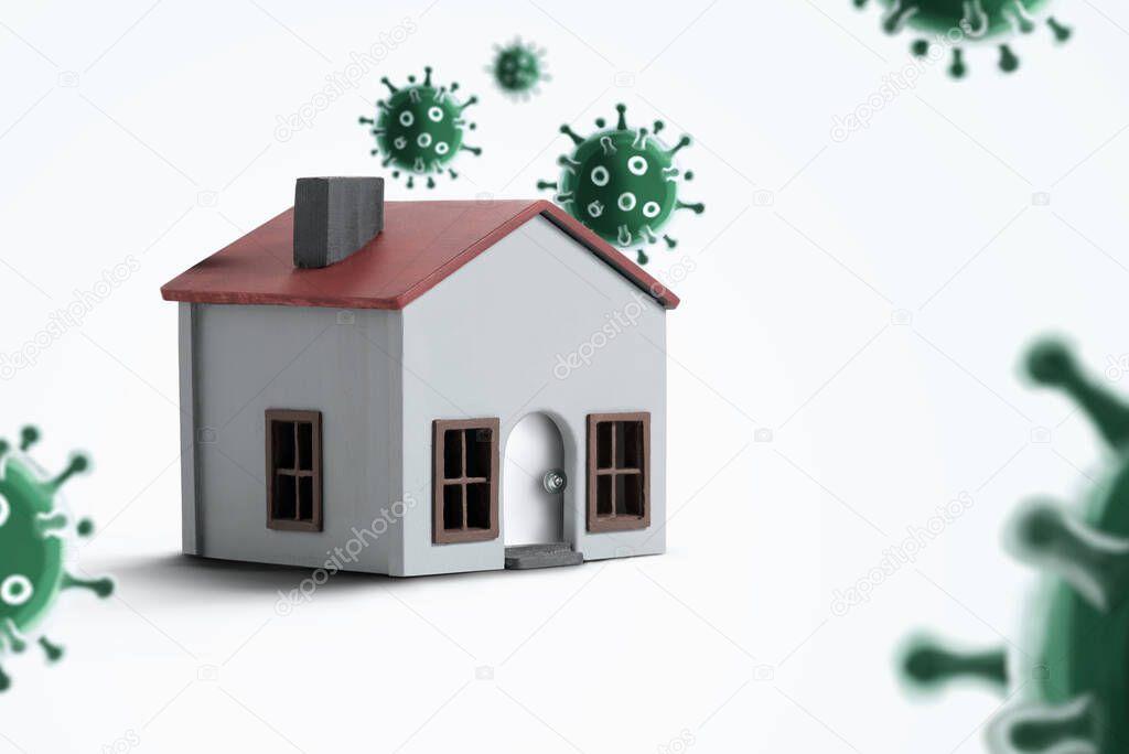 Model house on a white background with viruses around. It gives the message stay at home and work at home.