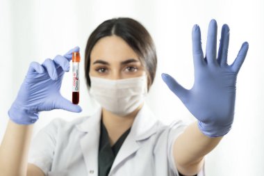 Cerrahi maskeli, mavi renkli muayene eldivenli, beyaz bir arka plan üzerinde 