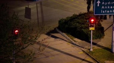 İzmir, Türkiye - 12 Nisan 2020: Yolun kavşağı. Kırmızı, sarı ve yeşil ışıkların değiştiğini görüyoruz ama araba yok. Akşamları Manavkuyu ilçesi Bayrakli İzmir 'de. Geceyarısı görüntüleri