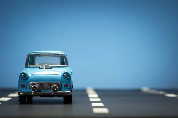 Εμπρόσθια Όψη Μπλε Αυτοκινήτου Ασφαλτοστρωμένο Δρόμο Και Μπλε Φόντο — Φωτογραφία Αρχείου
