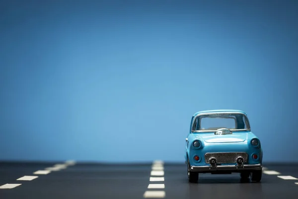 Εμπρόσθια Όψη Μπλε Αυτοκινήτου Ασφαλτοστρωμένο Δρόμο Και Μπλε Φόντο — Φωτογραφία Αρχείου
