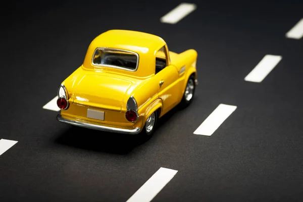 Visão Traseira Carro Brinquedo Amarelo Uma Estrada Asfalto — Fotografia de Stock