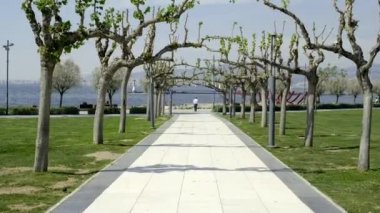 İzmir, Türkiye - 20 Nisan 2020: Saat kulesi yakınlarındaki Konak İzmir 'de ağaçların arasında yürümek ve Bihrat Mavitan' ın yaptığı Geminin kemik heykeli.