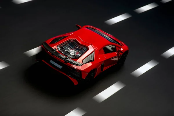 道路レーンとアスファルトの背景に赤いスポーツカーの上と後ろのビュー — ストック写真