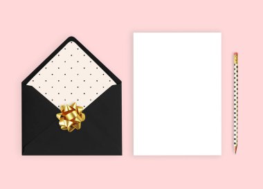 Düğün davetiyesi mockup. Pembe bir arka plan, düz lay, zarf kartı ile