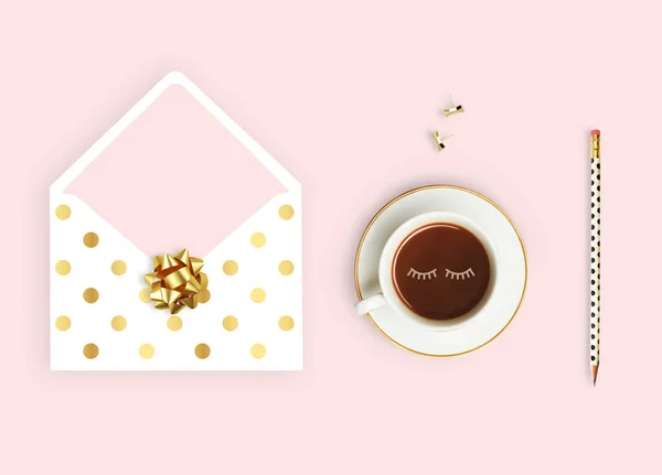 Acostado. Fondo rosa, sobre patrón de polka oro, taza de café y lápiz. Escritorio de negocios . —  Fotos de Stock