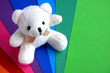 Gökkuşağı şeklinde çok renkli güzel bir karton ve peluş bej renkli yumuşak bir oyuncak ayı. Okul malzemeleri. Her türlü reklam geçmişi ve tebrik kartları için uygundur.