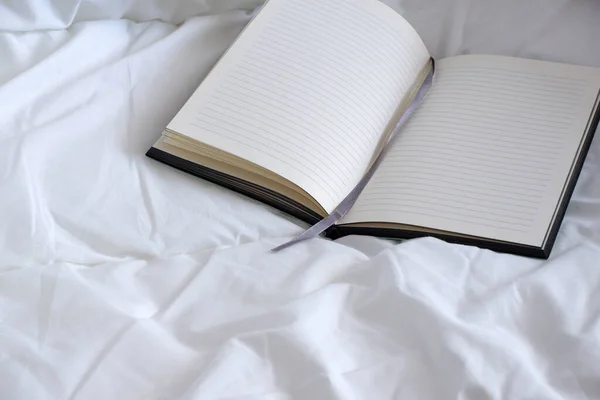 白いベッドの中の緑のノート 居心地のよさ ミニマリズム — ストック写真