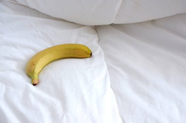 Çarşafların üzerinde muz. Beyaz dokular. Minimalizm. Sıcaklık.