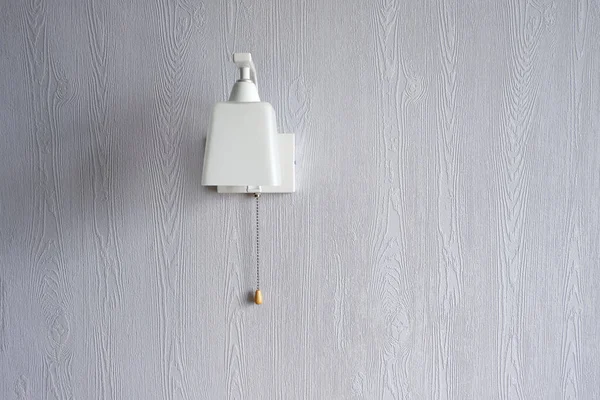 Minimalistic, stylish, white wall lamp on a blue wall. Stylish interior. Coziness.