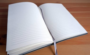 Şık ahşap bir masanın üzerinde bir kitap. Güzel bir iç mekan. Model