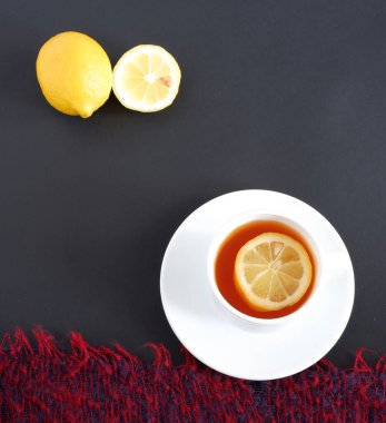 Siyah arka planda limonlu çay. Set: Beyaz arkaplanda seramik bardak ve fincan tabağı. Güzel reklam arkaplanı