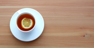 Siyah çay ve masada bir dilim limon olan bir kupa. Güzel reklam arkaplanı