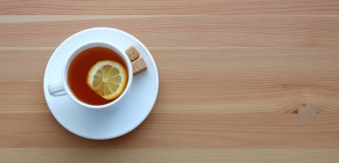 Siyah çay ve masada bir dilim limon olan bir kupa. Güzel reklam arkaplanı