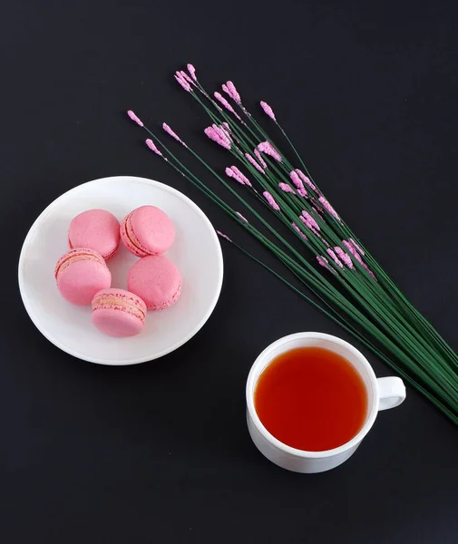 Makronen Und Eine Tasse Tee Auf Schwarzem Hintergrund Süßigkeiten — Stockfoto