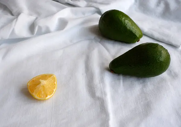 Два Здоровых Авокадо Кусочек Лимона Белой Ткани Белая Ткань Текстуры — стоковое фото