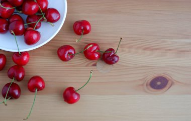 Tahta masadaki bir tabakta kirazlar. Özgeçmiş için uygun