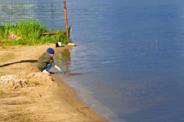 Su kenarında oynayan küçük çocuk.