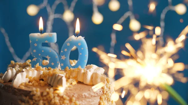 Gâteau d'anniversaire avec 50 bougies numériques et scintillant brûlant sur fond bleu. Gros plan — Photo