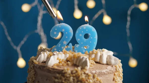 ライトによって火にセットされた青の背景に29番のキャンドル付きの誕生日ケーキ。閉鎖 — ストック写真