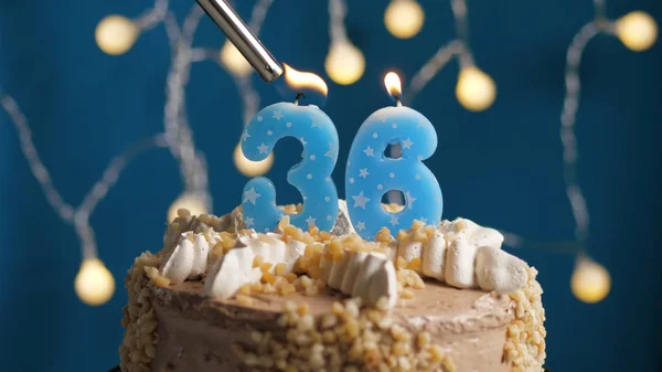 ライトによって火にセットされた青の背景に36番のキャンドル付きの誕生日ケーキ。閉鎖 — ストック写真