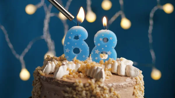 Birthday cake with 68 number candle on blue backgraund set on fire by lighter. Close-up — Stock Photo, Image