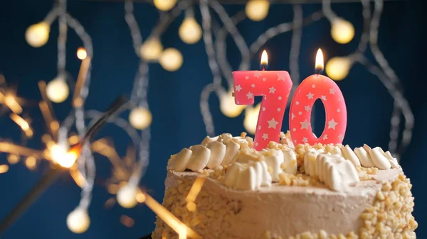 70番のピンクのキャンドルとブルーの背景に燃える輝きを持つ誕生日ケーキ。閉鎖 — ストック写真