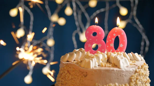Birthday cake with 80 number pink candles and burning sparkler on blue backgraund. Close-up — Stock Photo, Image