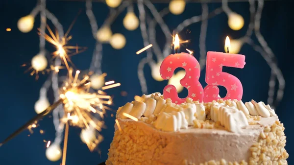 Bolo de aniversário com 35 número de velas rosa e queimando sparkler em backgraund azul. Close-up — Fotografia de Stock