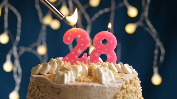 Születésnapi torta 28 számjegyű gyertyával, kék hátizsákkal, öngyújtóval felgyújtva. Közelkép — Stock Fotó